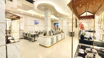 A spacious hotel lobby with a central island, seating areas, and a modern ceiling design.