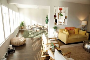 A modern living room with a sofa, coffee table, and dining area.