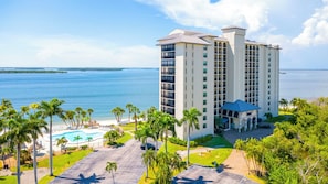 A high-rise hotel with a pool, palm trees, and a view of the ocean. - Sanibel Harbour Resort Harbour Tower 1212: 3 Bedroom Dream Vacation Rental offers stunning views! (Fort Myers)