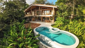 A two-story house with a swimming pool, surrounded by lush greenery. - Bali Style Villa- Ocean view, AC,  Salt water pool, amazing kitchen! (Santa Teresa)