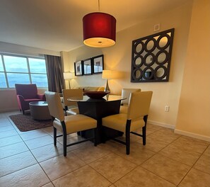 A dining area with a table, chairs, a red pendant light, and a decorative wall piece. - 2-bedroom condo in terrific Las Vegas with AC and fitness room (Las Vegas)