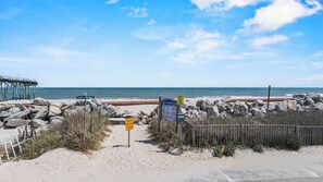 A beach with a wooden pier, a closed beach access sign, and a salt marsh sign. - New! Coastal Condo - Pool with Marsh + Ocean Views (Carolina Beach)