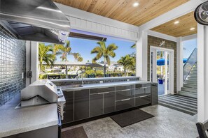 Eine moderne Küche mit Blick auf Palmen und einen Pool.