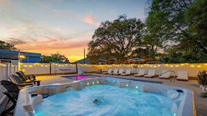 A hot tub with a pool, lounge chairs, and string lights. - Bijou House Unit 2 - 5BR w/ Ocean Views + Heated Pool & Hot Tub (Walk to Beach!) (North Myrtle Beach)