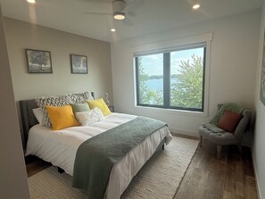 Un dormitorio con una cama grande, una ventana con vistas y un ventilador de techo.