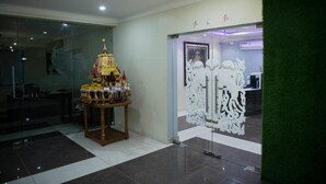 A reception area with a decorative altar, a glass partition, and a green wall. - Airavat (Bhubaneshwar)