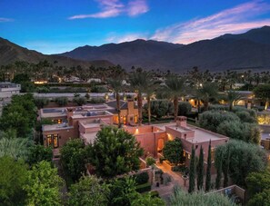 A residential area with modern architecture, including a house with a flat roof and a courtyard surrounded by trees and palm trees. - Moroccan Desert Oasis in Serene Neighborhood (Palm Springs)