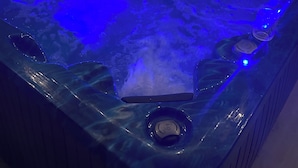 Ein Whirlpool mit blauer Beleuchtung und Bedienfeld.