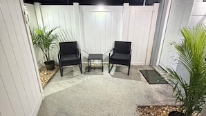 A patio area with two chairs, a small table, and potted plants. -     Modern & Cozy Apartment Near Everything You Need! (Valrico)