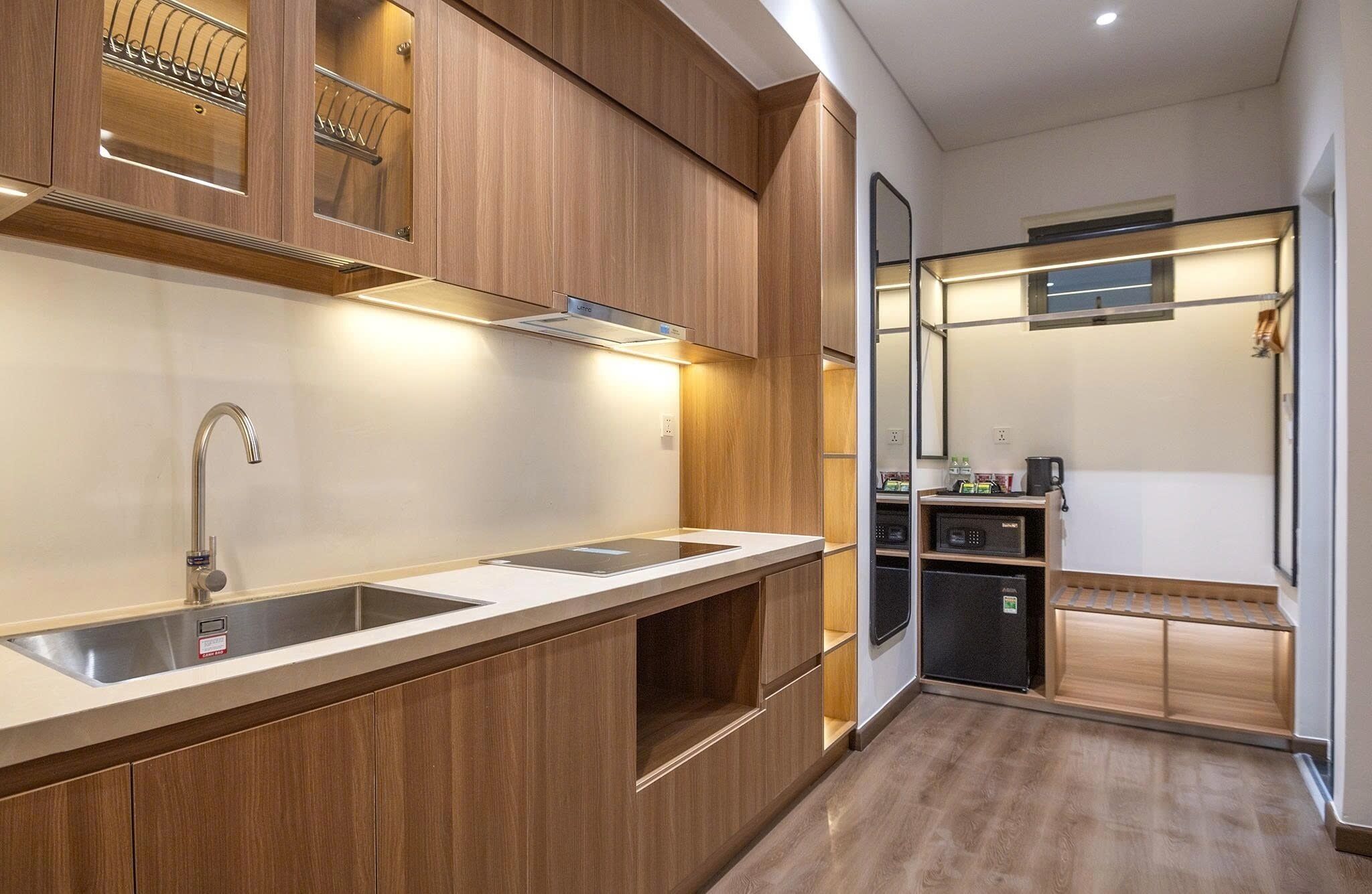 A modern kitchen with wooden cabinets, a stainless steel sink, and a built-in oven.