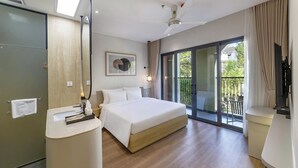 A hotel room with a bed, a round mirror, a bedside table, a ceiling fan, and a balcony with a view. - Soluna Dalat Hotel (Xuan Huong - Da Lat)
