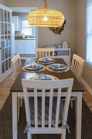 A dining table set with plates, cutlery, and napkins. - Coastal Home on Wrightsville Beach on Harbor Island (Wrightsville Beach)