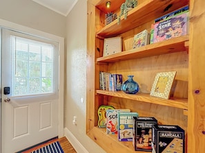A wooden bookshelf with various board games and books. - The Peacock House - Vintage Downtown Charm (Ocala)