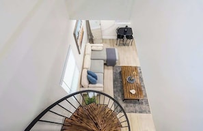 A modern living room with a sofa, coffee table, and a staircase.