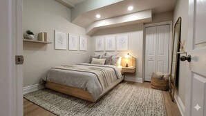 A bedroom with a bed, bedside lamp, wall art, and a door.