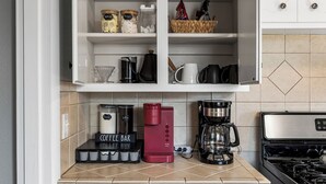 A kitchen with a coffee station, including a coffee maker, a red espresso machine, and a coffee bar sign. - Owasso Home/ 5 beds 2 bath/ King (Owasso)