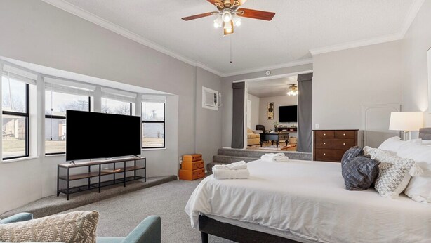 A bedroom with a bed, a TV, a ceiling fan, and a window. - Owasso Home/ 5 beds 2 bath/ King (Owasso)