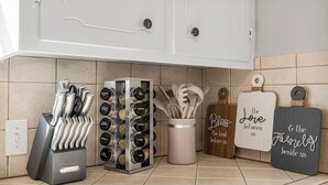 A kitchen with a knife block, spice rack, and decorative signs. - Owasso Home/ 5 beds 2 bath/ King (Owasso)