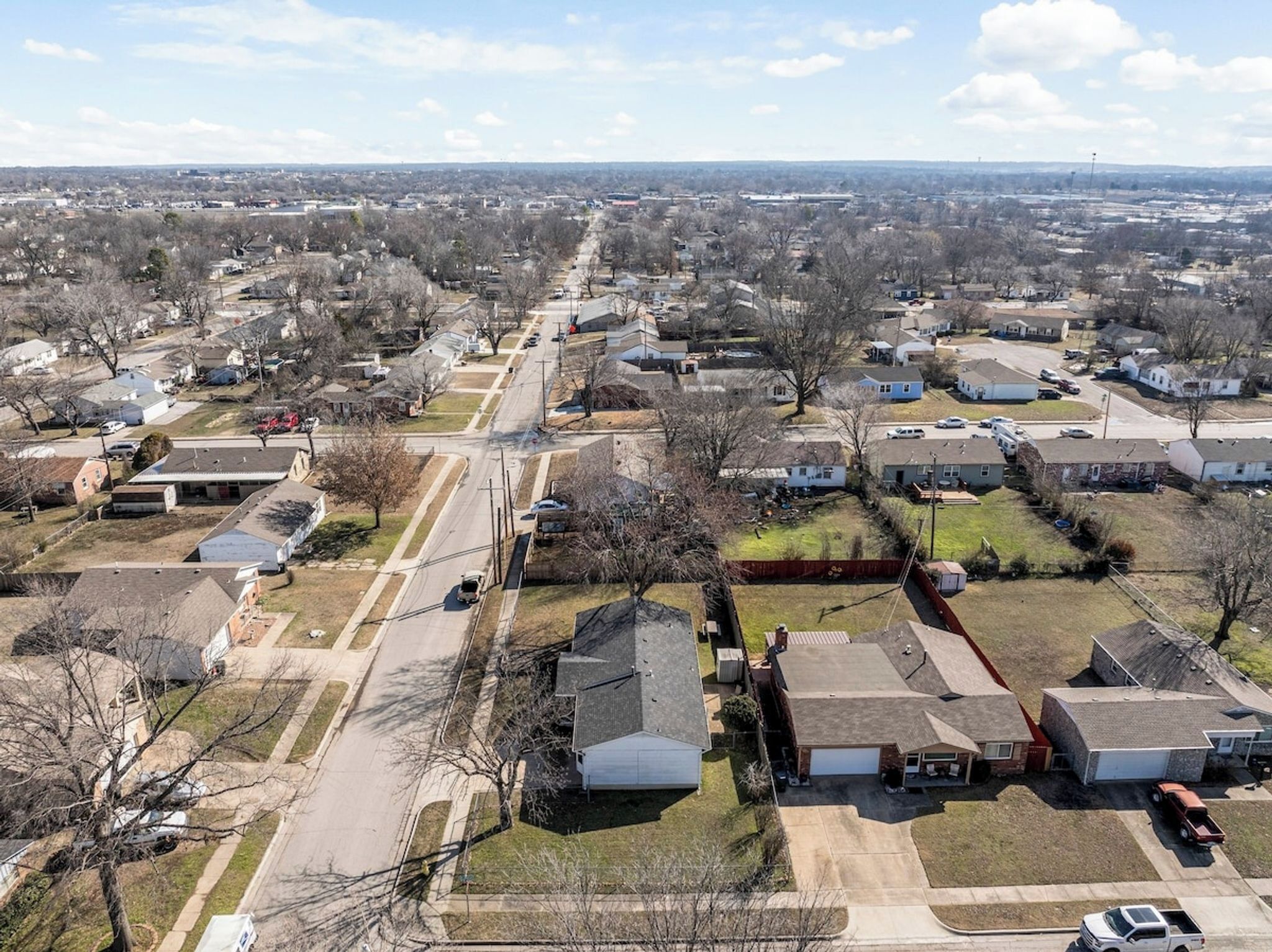 Une vue aérienne d’un quartier résidentiel avec des maisons, des rues et un ciel dégagé.