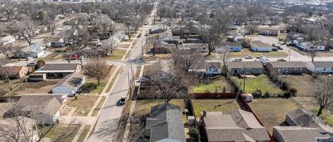 Une vue aérienne d’un quartier résidentiel avec des maisons, des rues et un ciel dégagé.