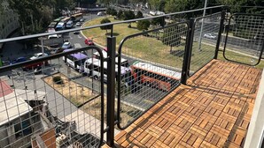 Un balcon donnant sur un parking et des immeubles.