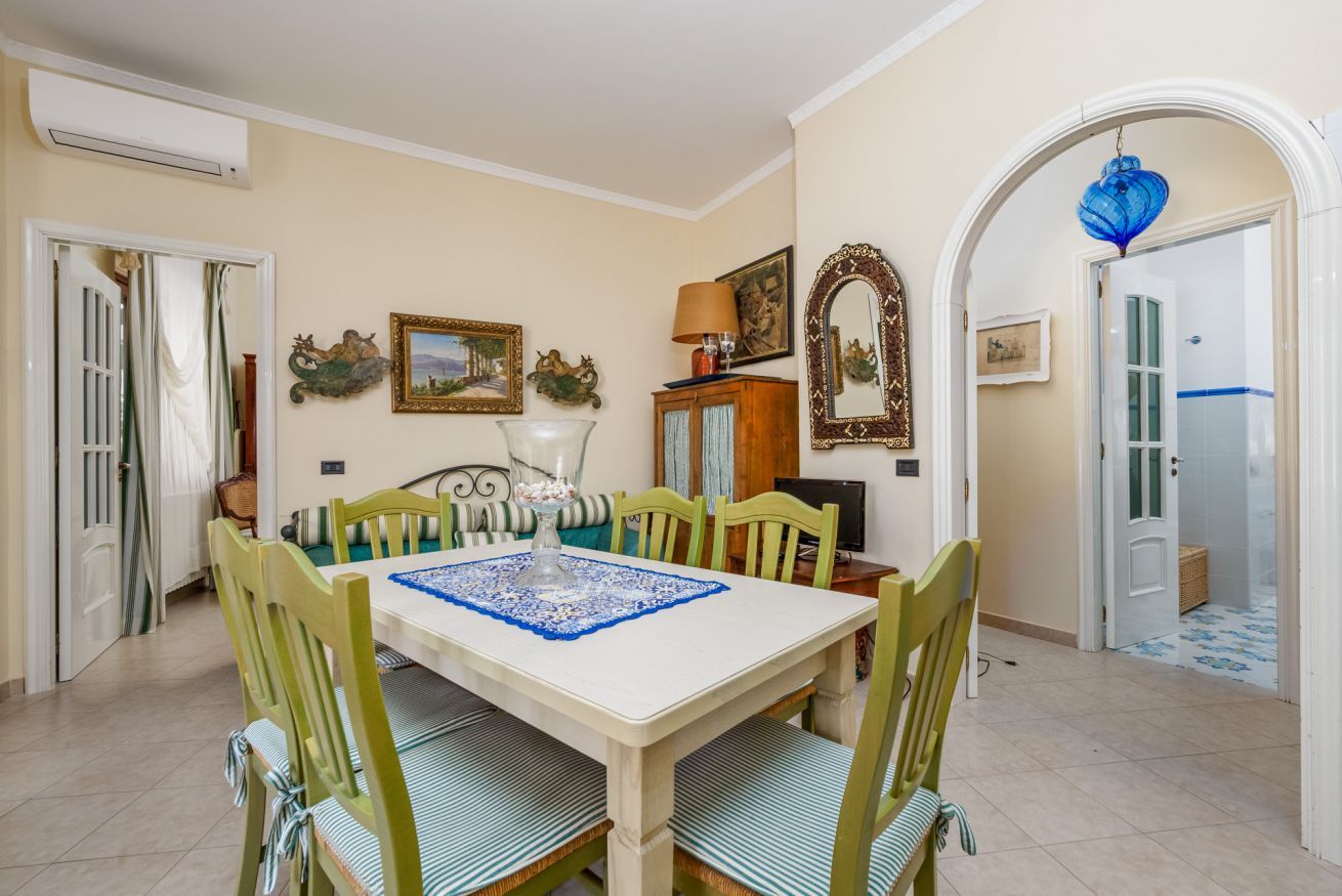 A dining area with a table set for six, surrounded by six chairs.