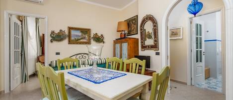 A dining area with a table set for six, surrounded by six chairs.
