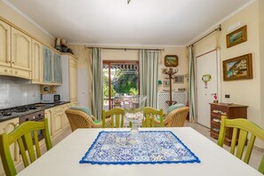 A dining area with a table set for four, surrounded by wicker chairs. - Positano Elegant Terrace – Panoramic Home with Terrace in the Heart of Positano (Positano)