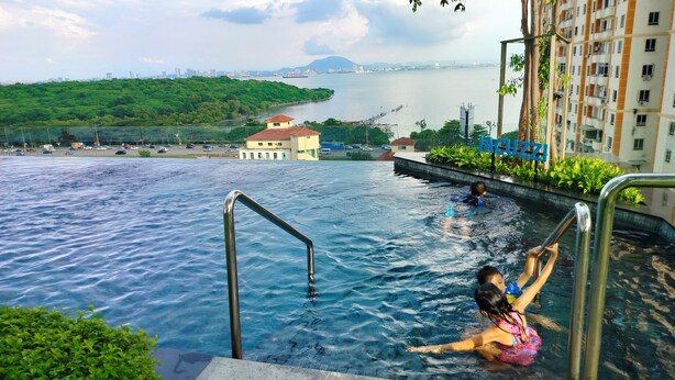 A swimming pool with a view of a cityscape and a body of water.