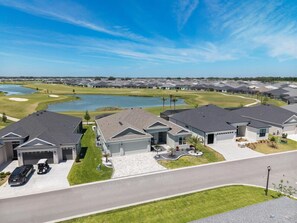 A residential area with modern houses, a golf course, and a lake. - Edenfield Championship View Estate (Sumterville)