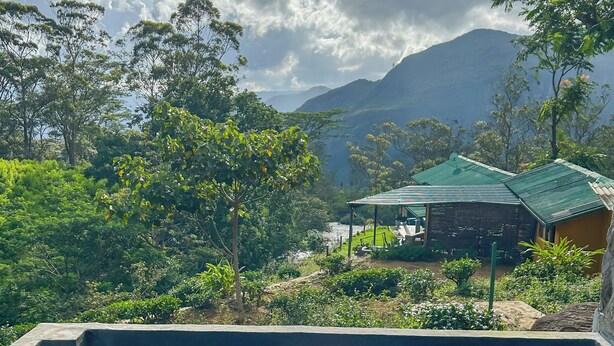 A swimming pool with a view of a mountainous landscape and a small building with a green roof. - Unseen Knuckles Eco Boutique  (Tawalanthanna)