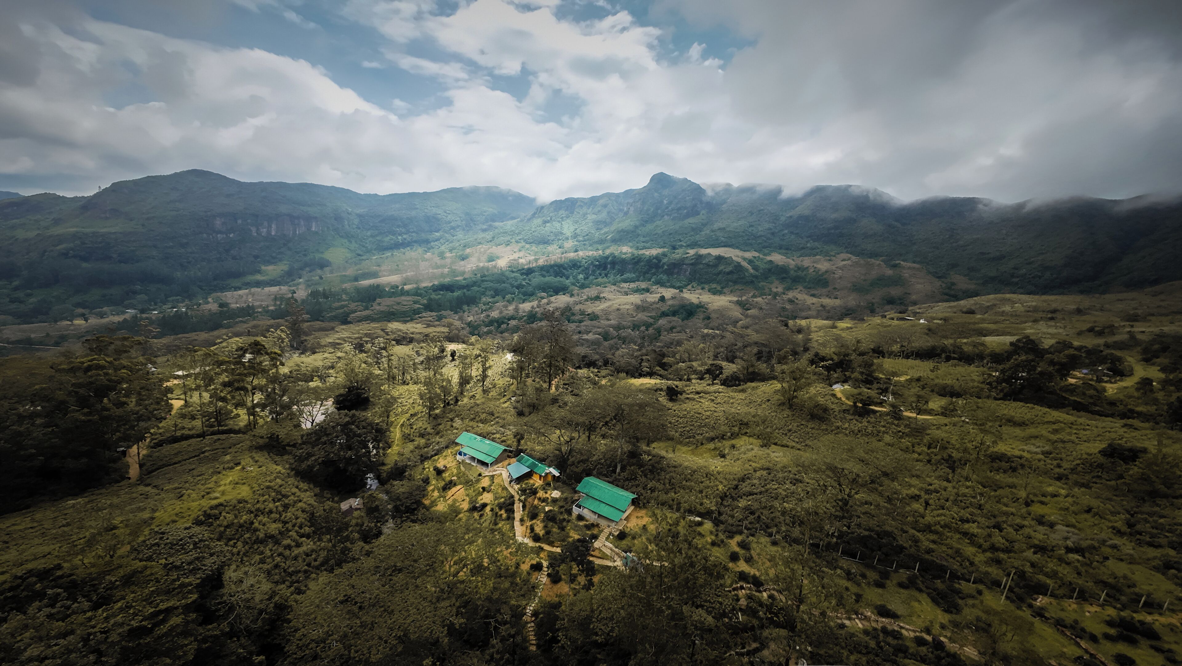 Paisaje montañoso con edificios dispersos y cielo despejado.
