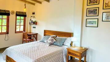 A bedroom with a wooden bed, bedside tables, a desk, and a shelf with items.