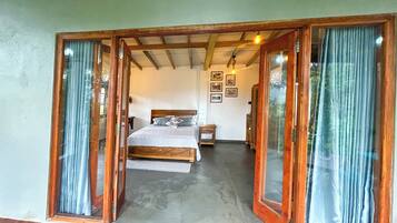 Un dormitorio con cama, mesita de noche, cómoda y ventana con cortinas.
