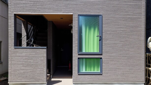 A modern building with a brick facade, a door with a window, and a staircase leading to the entrance. - Ars Kiyosumi shirakawa (Tokyo)
