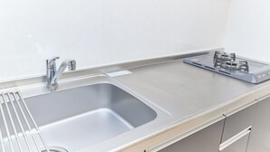A stainless steel kitchen with a sink, faucet, and a gas stove. - Ars Kiyosumi shirakawa (Tokyo)