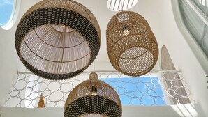 A ceiling with geometric pendant lights and a view of the sky through a window. - Casa Nimare (Ungasan)