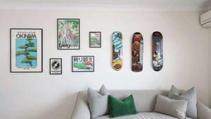 Una pared con carteles enmarcados y cuatro patinetas.