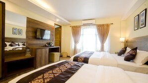 Una habitación de hotel con dos camas, televisión, escritorio y espejo.