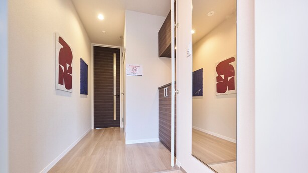A hallway with wooden flooring, a door with a 'No Entry' sign, and abstract wall art. - ShaMaison richelive Yoshizuka by Tranova (Fukuoka)