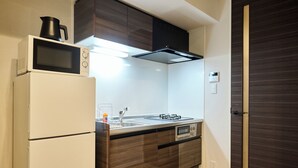 A compact kitchen with a refrigerator, microwave, stove, and sink. - ShaMaison richelive Yoshizuka by Tranova (Fukuoka)