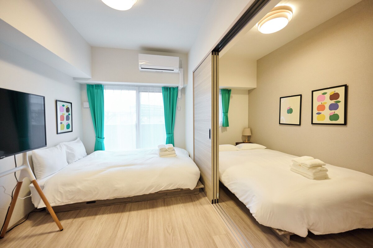 Ein Hotelzimmer mit zwei Betten, einem Fernseher und Bildern an den Wänden.