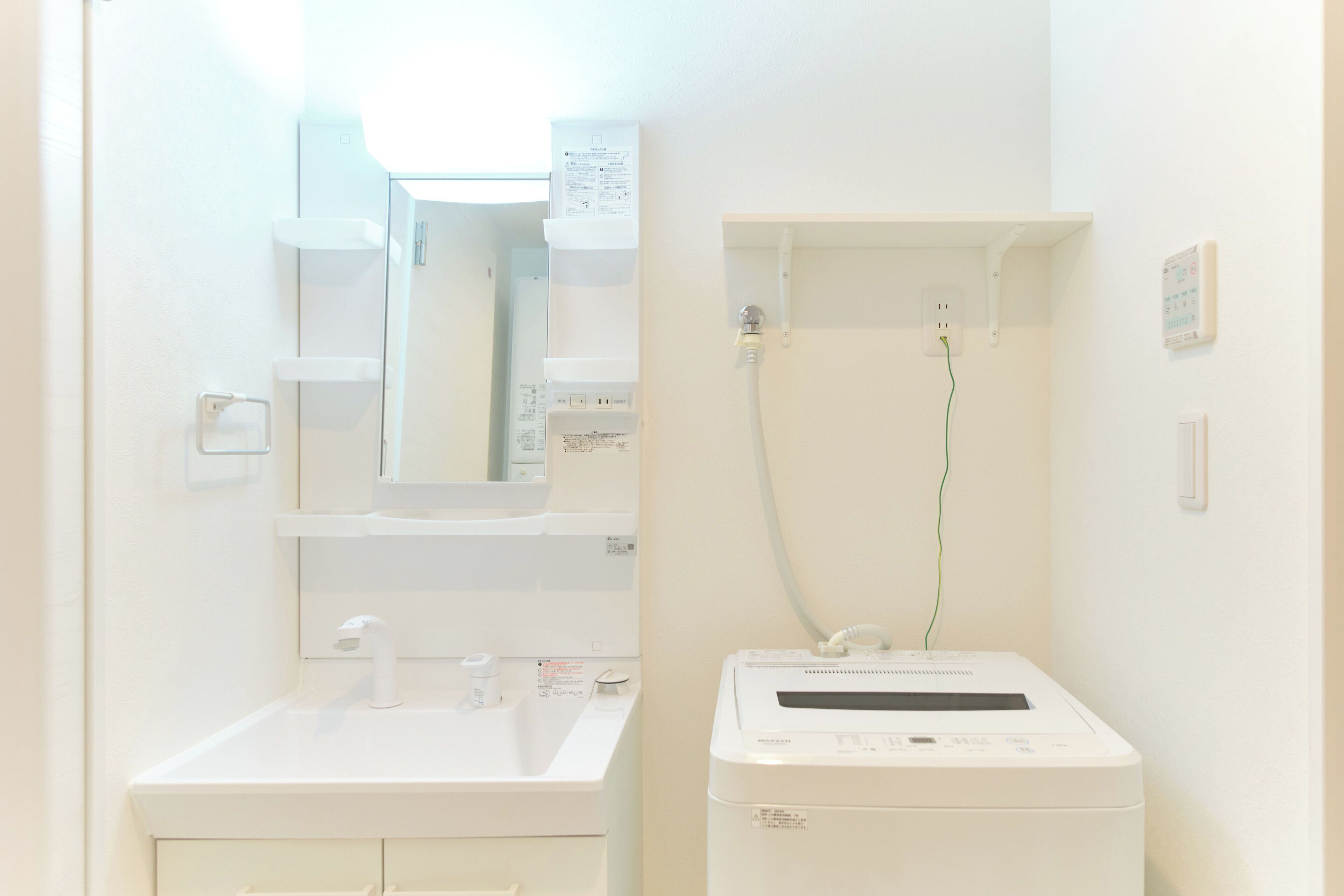 Ein Badezimmer mit Waschbecken, Spiegel und einer weißen Waschmaschine.