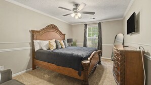 A bedroom with a bed, dresser, ceiling fan, and a television on the wall. - The Delta Dream Cottage- minutes from Memphis (Horn Lake)