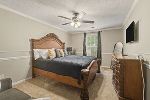 A bedroom with a bed, dresser, ceiling fan, and a television on the wall. - The Delta Dream Cottage- minutes from Memphis (Horn Lake)