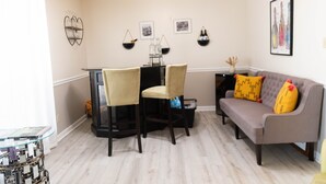 Una sala de estar con un sofá, dos sillones, una mesa de centro y una mesa de comedor.