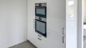 A kitchen with two ovens, a microwave, and a built-in refrigerator.