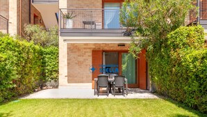 Un bâtiment moderne avec une façade en briques, un balcon agrémenté de mobilier d’extérieur et le logo d’« Immobiliare Stella » au-dessus de l’entrée.