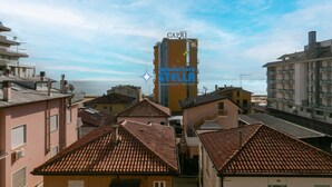Un edificio de varios pisos con una terraza en la azotea, un letrero que dice 'CAPRI' y el logotipo de 'immobiliare STELLA'.