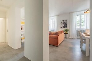 A modern interior with a sofa, dining table, and artwork. - Great Opera at Via Palermo (Roma)